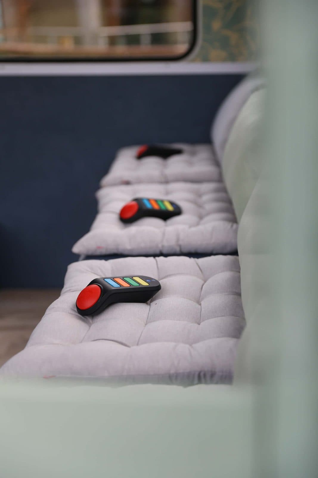 Les buzzers colorés de La Caravane Game posés sur la banquette de la caravane Suzanne, prêts pour le blind test