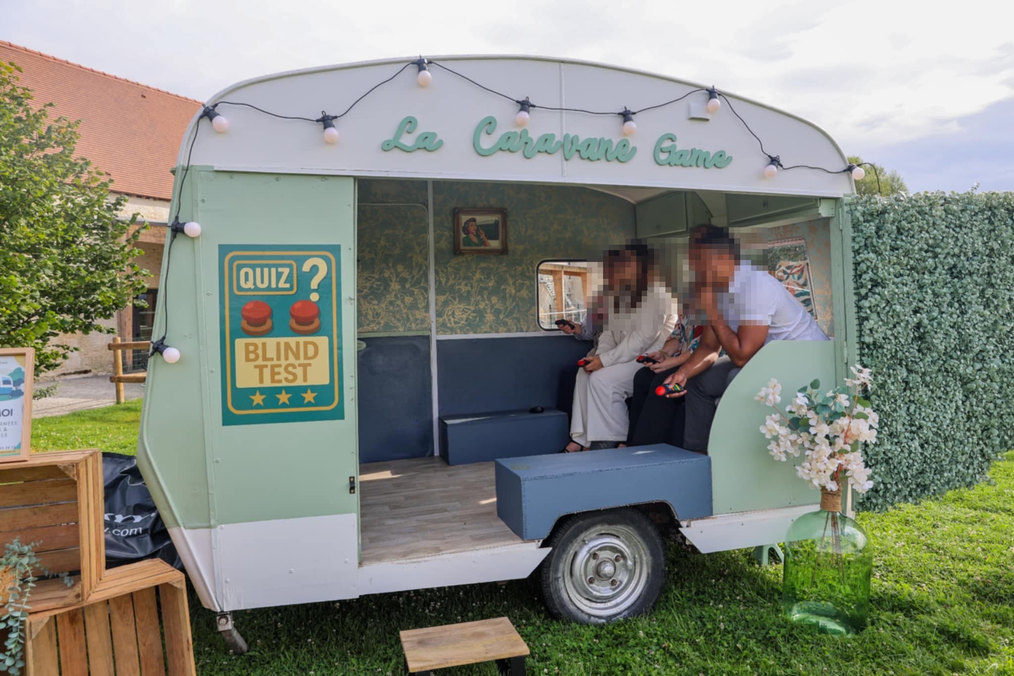 Invités en train de jouer au quiz et au blind test, assis dans la caravane Suzanne buzzers en main, lors d’un événement en Normandie